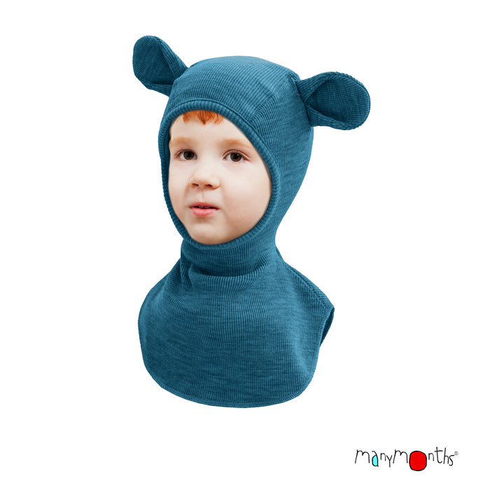 child wearing teal merino wool balaclava with teddy bear ears with 'manymonths' branding